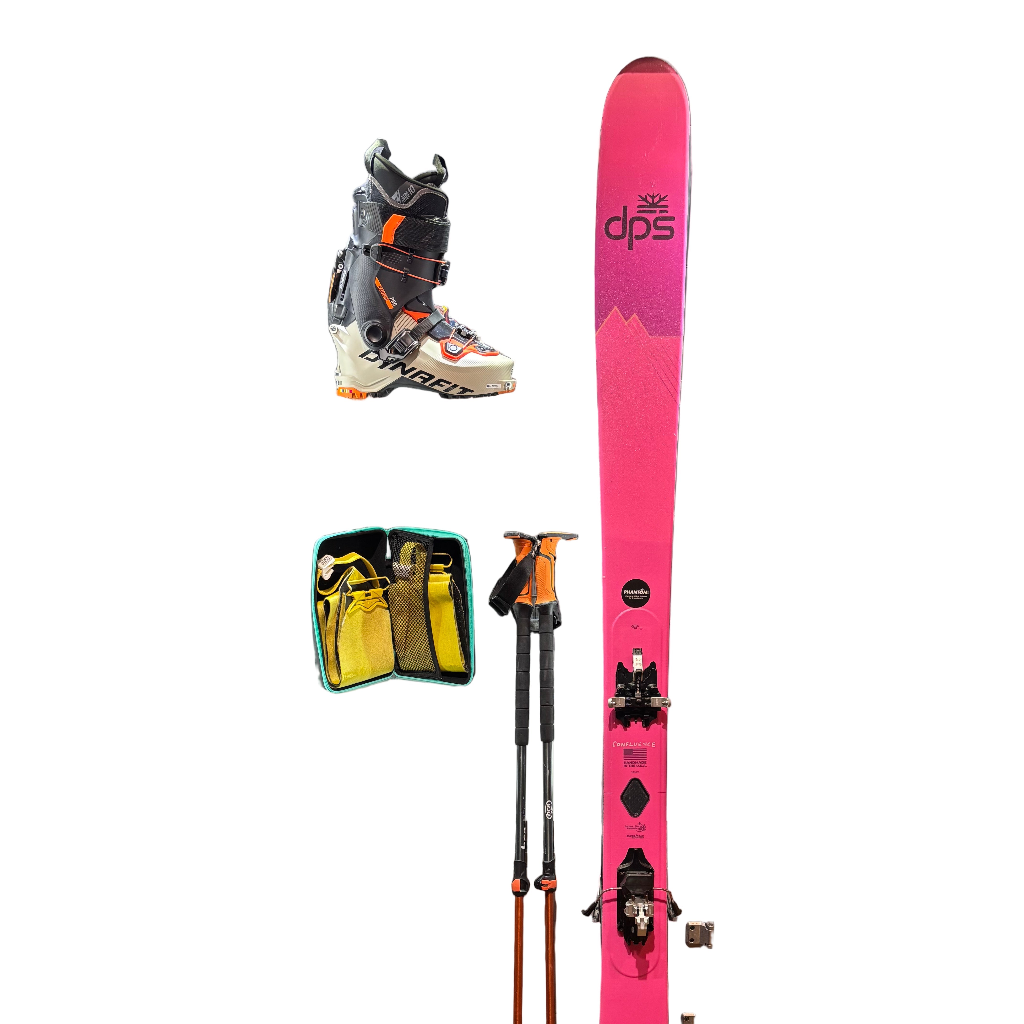 Pink DPS skis with bindings on a metal surface with other ski equipment in the background.