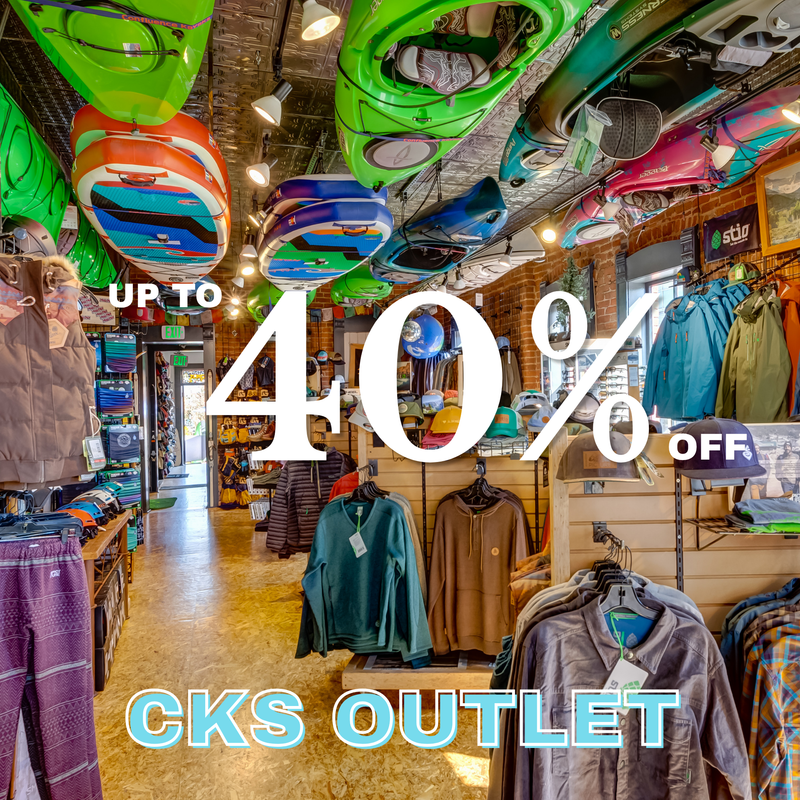 Store interior with clothing and promotional text for CKS Outlet sale.