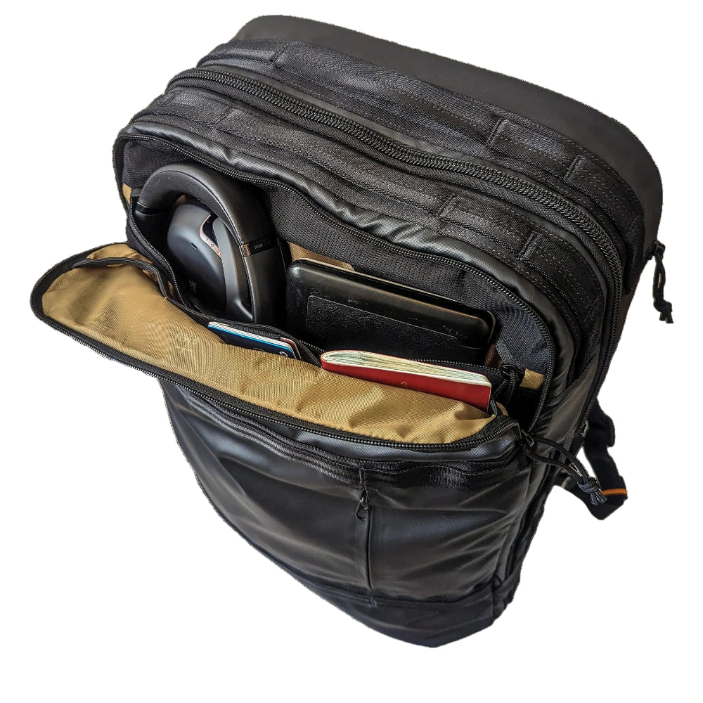 Black backpack with a compartment open, revealing a tablet and other items on a white background